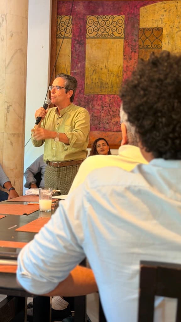 Maurício Rands fala ao microfone em reunião, de camisa verde-oliva