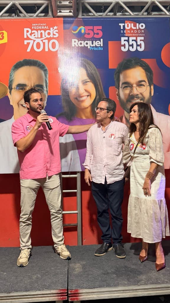 Maurício Rands em ato de campanha ao lado de apoiadores, com faixa 7010 ao fundo