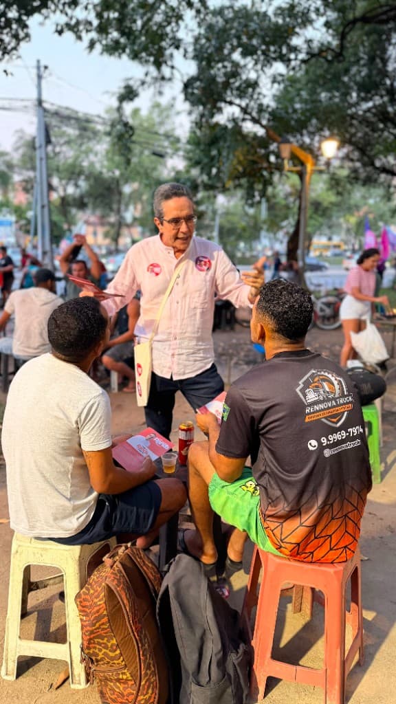 Maurício Rands conversa com eleitores em espaço aberto, com materiais da campanha nas mãos